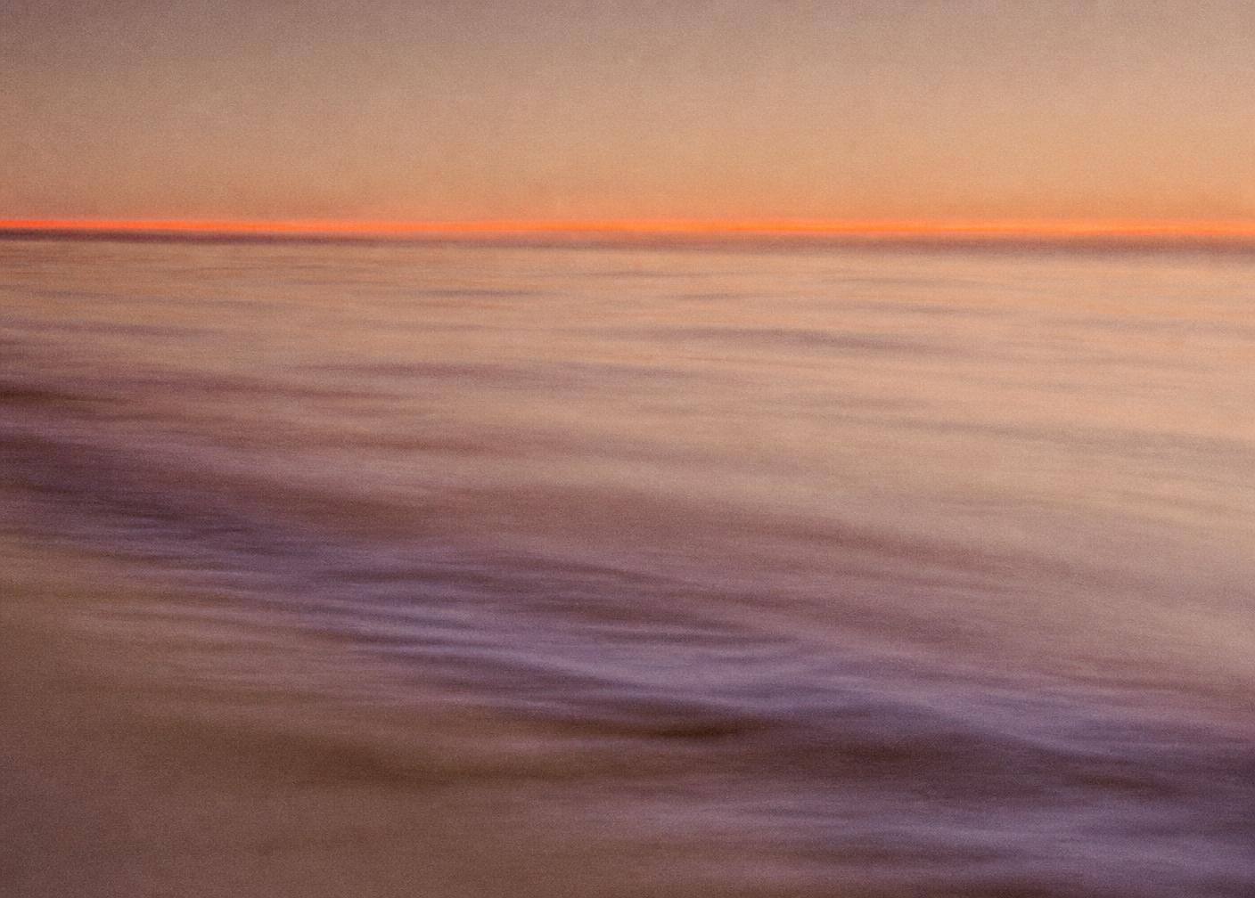 Mare aperto al tramonto, un orizzonte fluorescente sottile